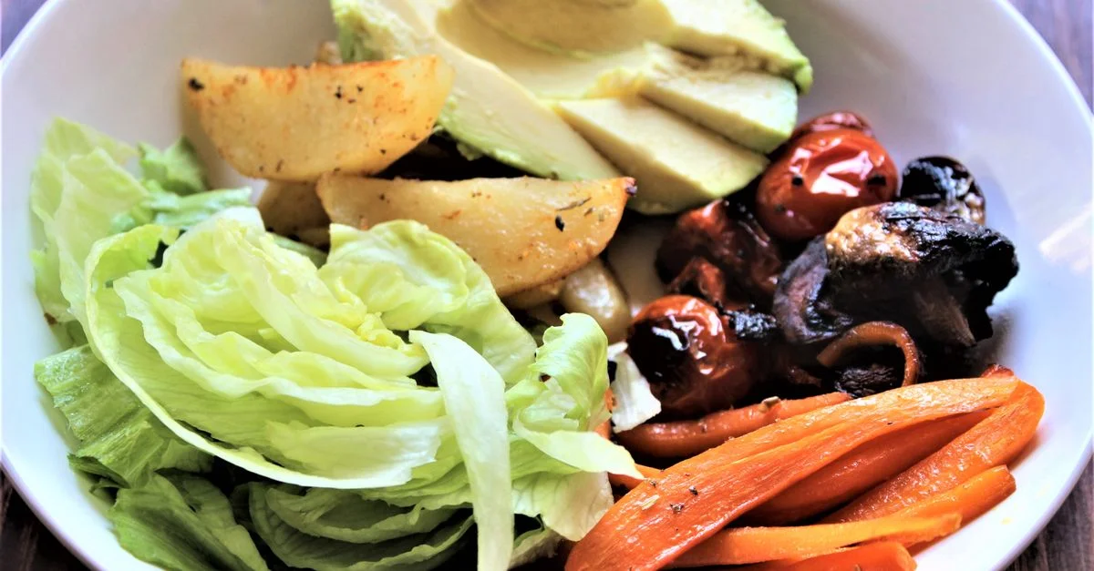 Délicieuse salade de légumes mélangés avec de la laitue fraîche, de l'avocat et des légumes rôtis, idéale pour une alimentation saine.