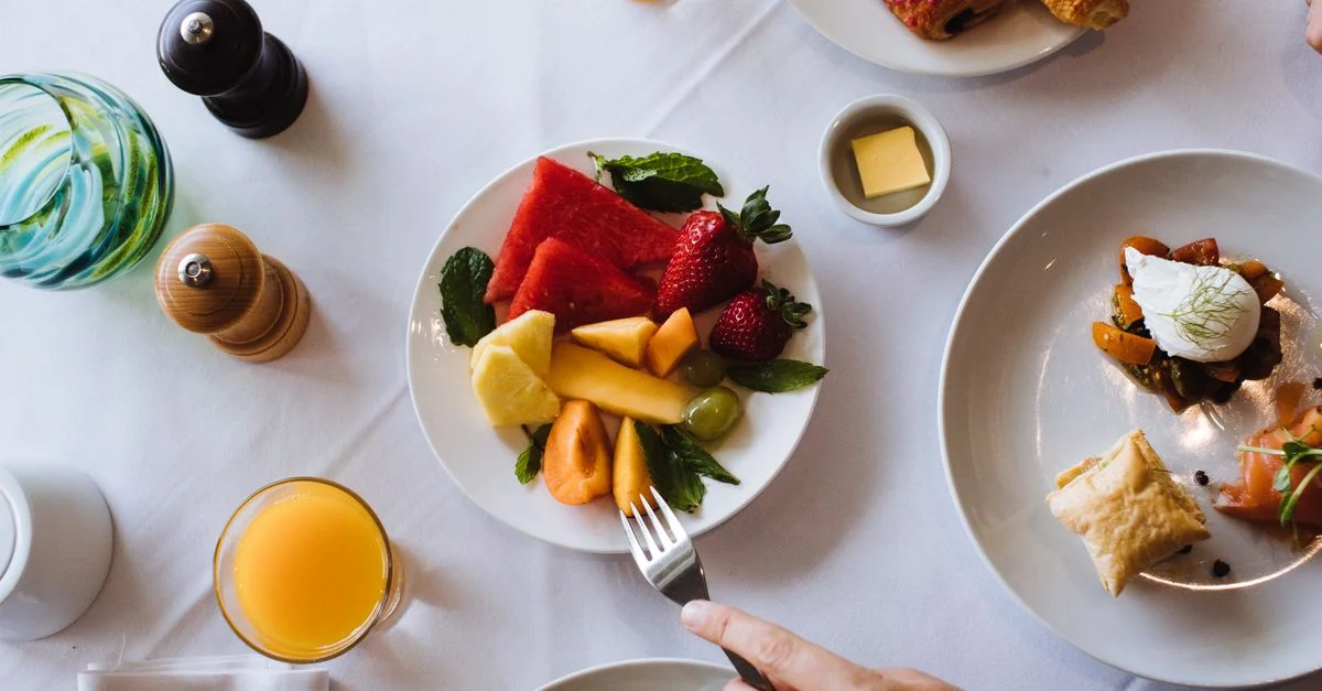 Vue aérienne d'un petit déjeuner sain avec des fruits, des pâtisseries et du jus.