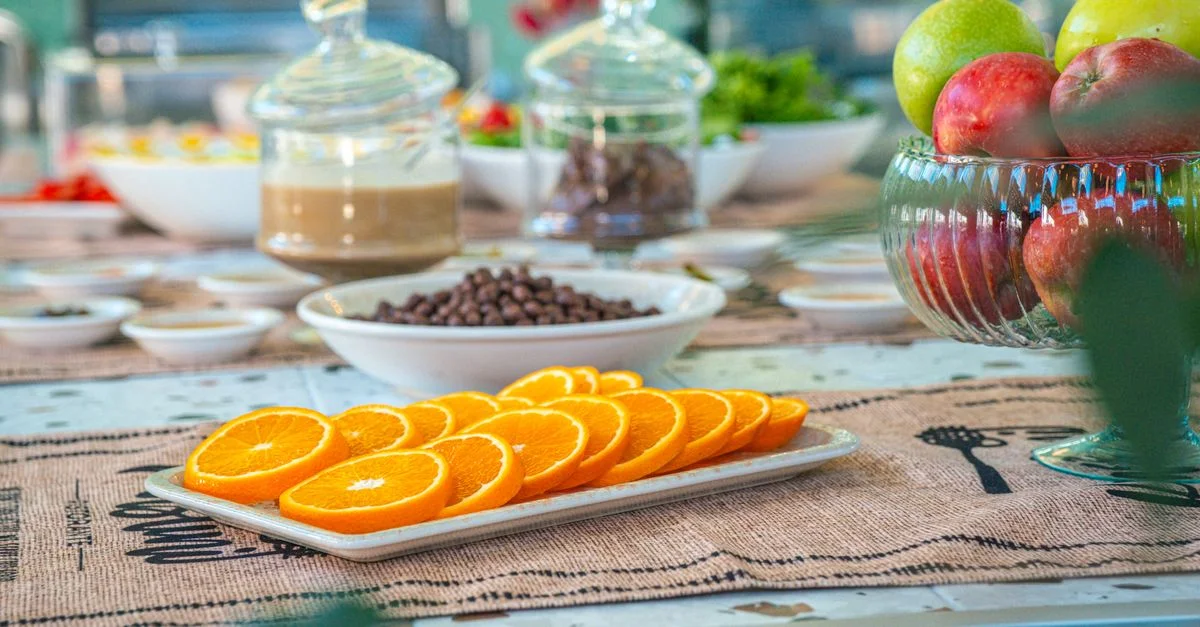 Mise en place d'un délicieux petit-déjeuner avec des fruits frais et des douceurs sur une table rustique.